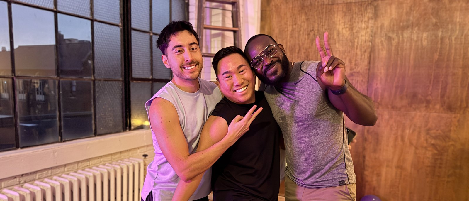 Three friends embracing after a Queer Pilates Club session